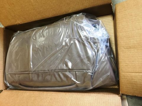 1996 Ford Bronco - A car seat cover is packaged in plastic within a cardboard box.