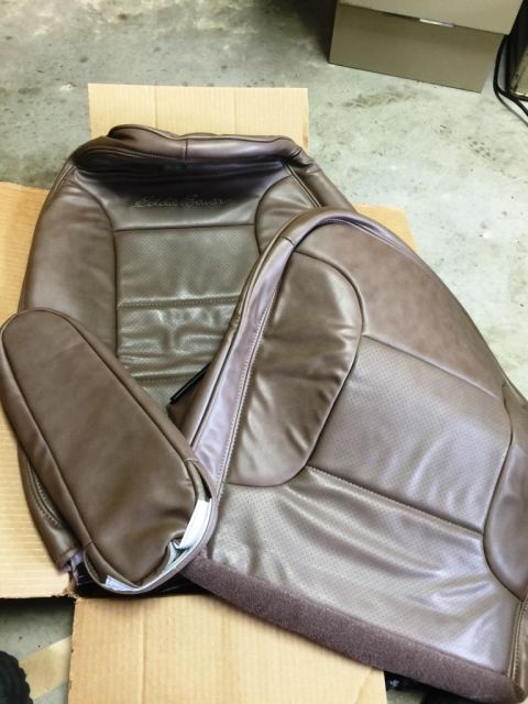 1996 Ford Bronco - Two brown leather car seats, possibly from an Eddie Bauer edition vehicle, are shown laid out on cardboard.