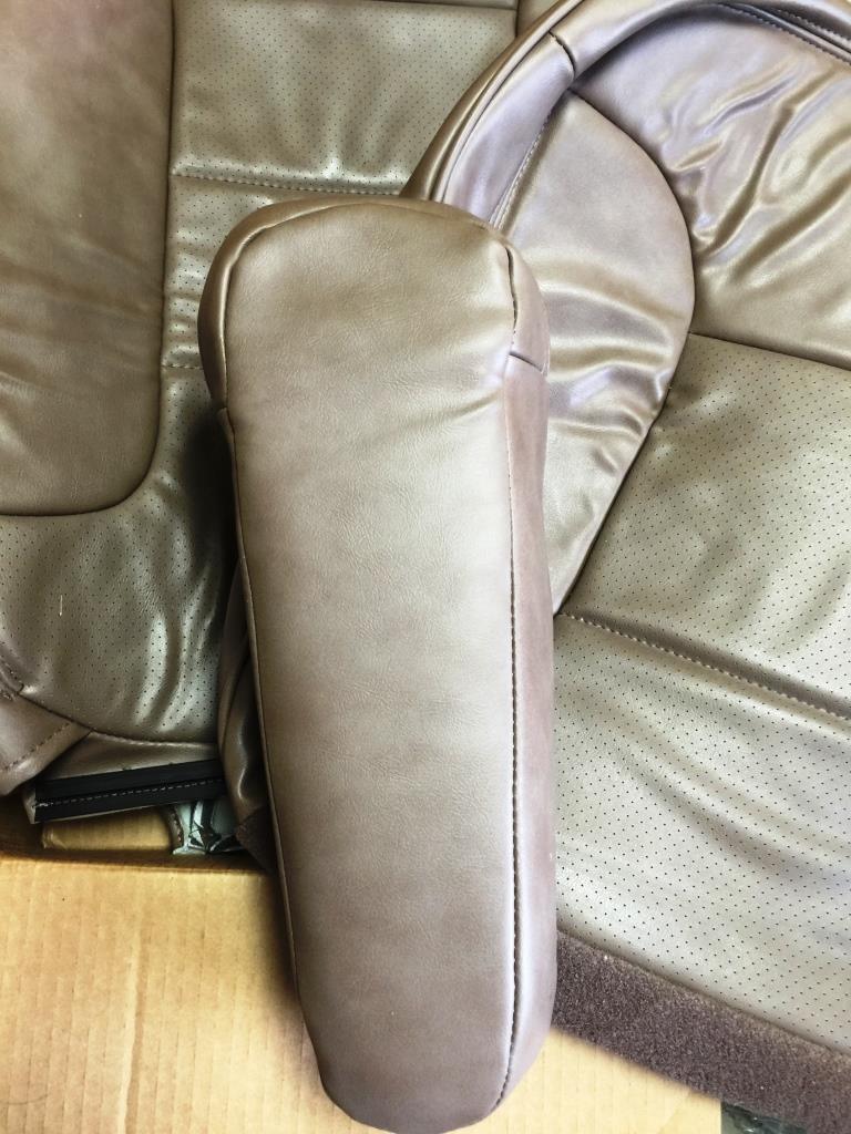tan leather car seat armrest and perforated seat fabric