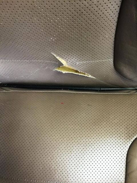 1996 Ford Bronco - A close-up view of a damaged car seat interior shows wear and tear on the upholstery.