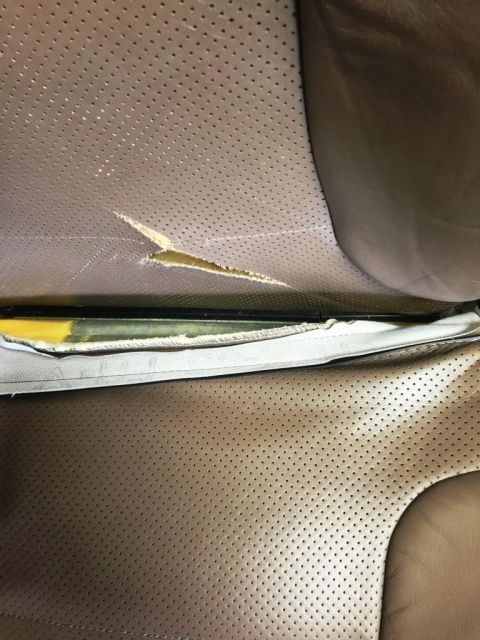 1996 Ford Bronco - Close-up view of a damaged leather seat interior, revealing torn upholstery and exposed foam.
