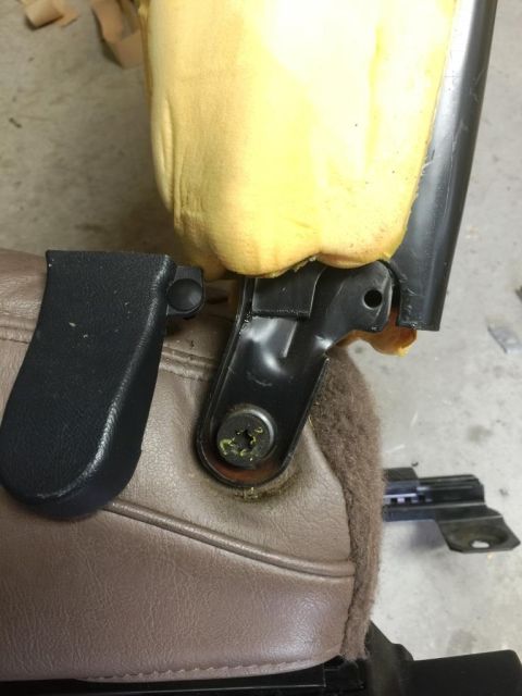 1996 Ford Bronco - Close-up of a car seat's mounting bracket, showing worn upholstery and foam padding.