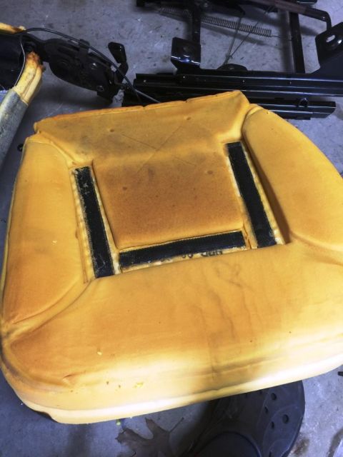 1996 Ford Bronco - The yellow foam cushion of a car seat is shown, with its metal frame visible behind it.
