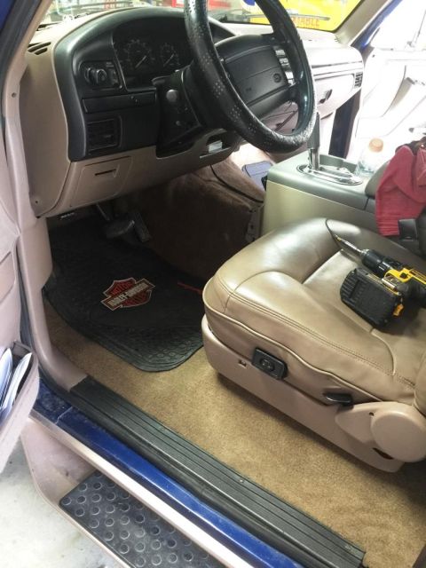 1996 Ford Bronco - The interior of a 1996 Ford Bronco shows a tan leather driver's seat and dashboard, with a drill resting on the seat.