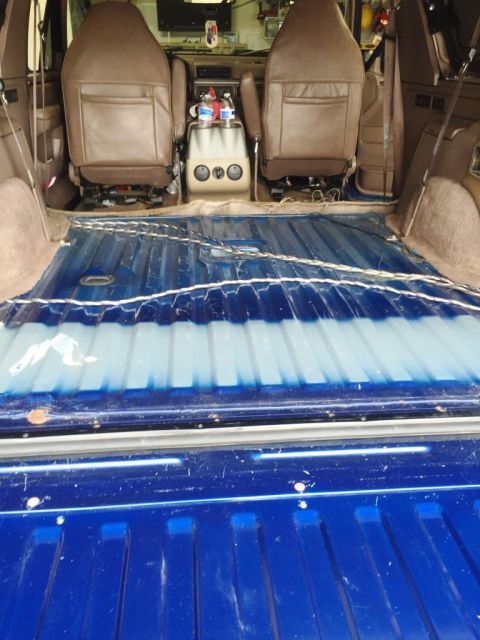 1996 Ford Bronco - The interior of a 1996 Ford Bronco, brown front seats and a blue-painted cargo bed.