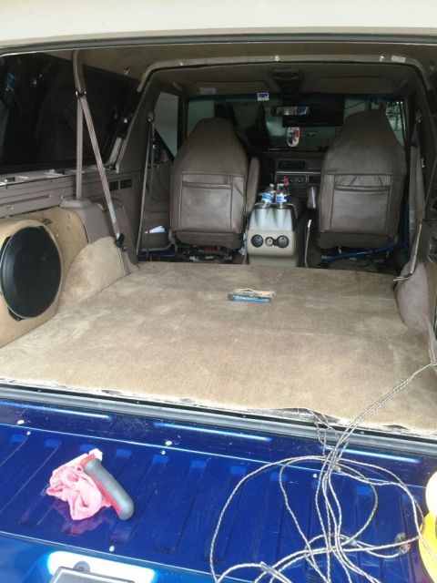 1996 Ford Bronco - The interior of a 1996 Ford Bronco shows a carpeted cargo area and brown leather seats.