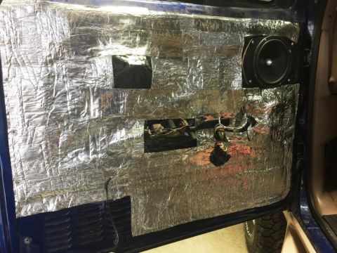 1996 Ford Bronco - Car door interior with sound deadening material and a speaker installed, wires visible.