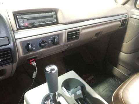 1996 Ford Bronco - The interior of a vehicle is shown, focusing on the dashboard and center console area.