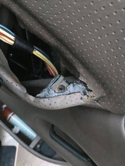 1996 Ford Bronco - Close-up of damaged car interior upholstery with exposed wiring and a metal mounting point.