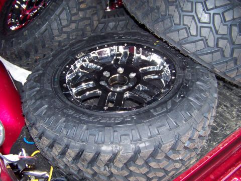 2005 Ford F-150 - Close-up of a chrome wheel and a set of off-road tires, likely in a truck bed.
