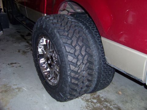 2005 Ford F-150 - Close-up of a truck's rear wheel and tire with a chrome rim and off-road tread.