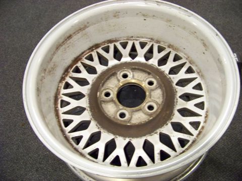 1999 Mercury Grand Marquis - A single white mesh alloy wheel shows signs of wear and rust, indicating it is a replacement part.