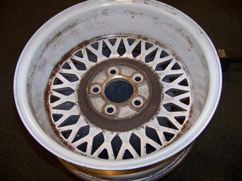 1999 Mercury Grand Marquis - A close-up view of a white mesh wheel, showing signs of rust and wear on its surface.