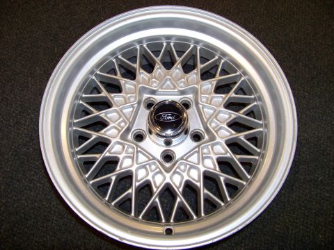 1999 Mercury Grand Marquis - A close-up of a silver mesh wheel with a Ford emblem in the center cap.