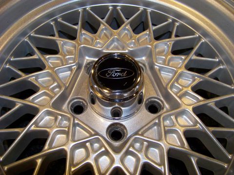 1999 Mercury Grand Marquis - Close-up of a silver mesh-style Ford alloy wheel with a chrome center cap reading Ford and a five-lug bolt pattern.