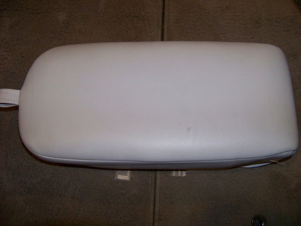 Light gray car armrest with a small strap on the left side