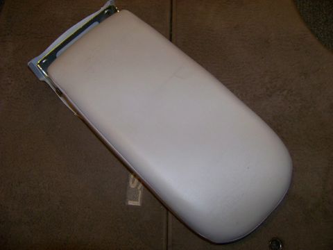 1999 Mercury Grand Marquis - This is a beige armrest with a metal bracket, likely an interior car part.