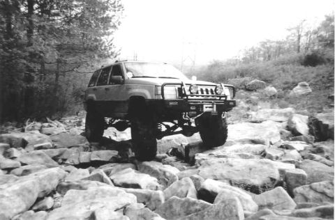 1978 Ford Bronco - This modified Jeep Grand Cherokee navigates a challenging rocky terrain with its suspension articulation.
