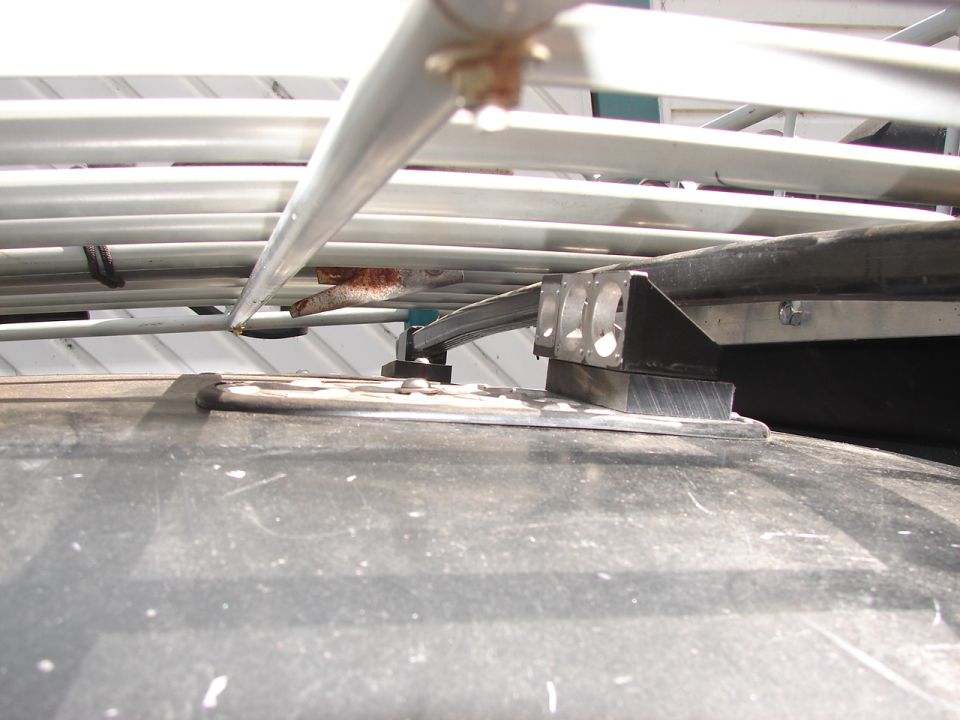 Close-up of roof rack mounting hardware on a dark vehicle roof