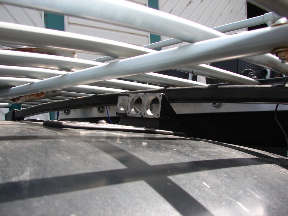 Close-up of a roof rack with two small auxiliary lights mounted on a bracket