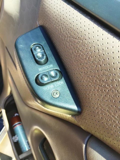 1996 Ford Bronco - Interior door panel of a 1996 Ford Bronco showing the power window and door lock controls.