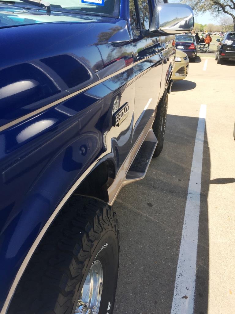 Side view of a blue 1996 Ford Bronco with tan trim and running boards