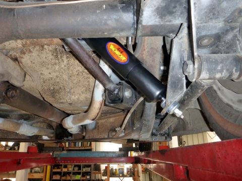 1964 Mercury Monterey - The underside of a vehicle is shown, focusing on the suspension system and a prominent shock absorber.