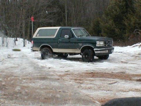 1993 Ford Bronco - Green and white 1993 Ford Bronco navigates a snowy terrain.