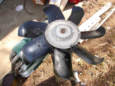 1973 Ford Ranchero - A disassembled engine cooling fan and exhaust manifold components are shown outdoors.