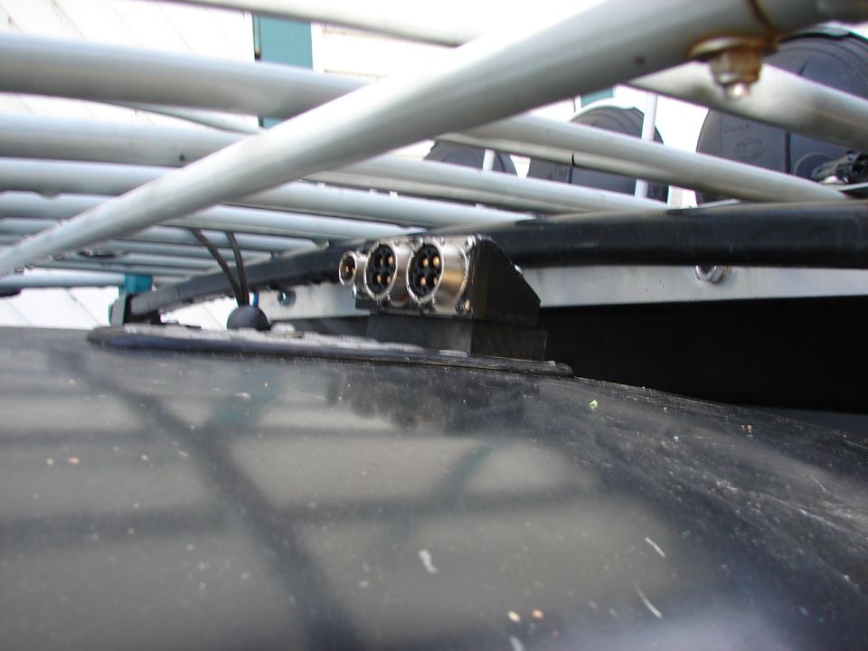 Roof rack with multiple electrical connectors mounted on a dark vehicle