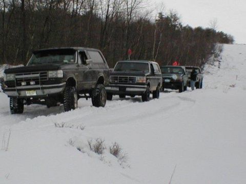 1993 Ford Bronco - Multiple Ford Broncos navigate a snowy landscape, suggesting an off-road or winter excursion.