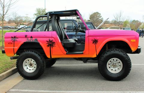 1979 Ford Bronco - This 1979 Ford Bronco features a vibrant sunset-themed paint job with palm tree decals.