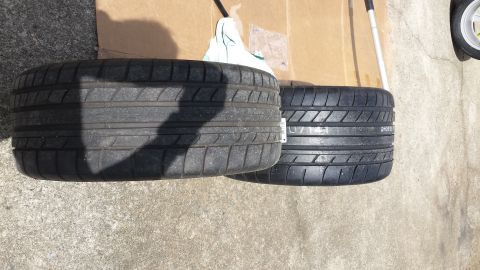1976 Ford Ranchero - Two tires are shown resting on a concrete surface with cardboard in the background.