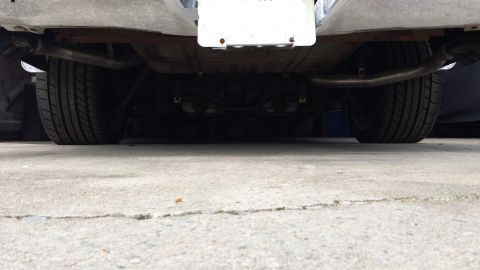 1976 Ford Ranchero - The underside of a vehicle is shown, featuring dual exhaust pipes, two tires, and a differential. A license plate is mounted above the diff…