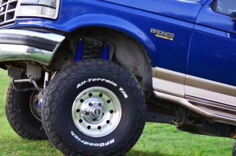 1996 Ford Bronco - Close-up of a 1996 Ford Bronco's front wheel and fender, highlighting the tire and body style.
