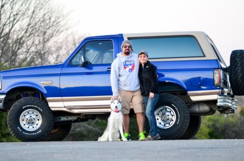 1996 Ford Bronco - A couple and their husky pose with a blue Ford Bronco, which appears to be from the early to mid-1990s.