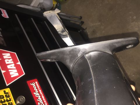 1995 Ford Bronco - A close-up shot shows a black plastic part with a metal piece attached, possibly a component from a vehicle. The part is resting on a black…