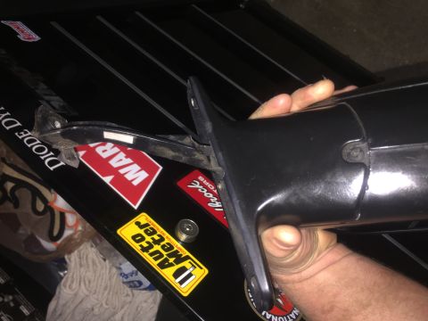 1995 Ford Bronco - A hand holds a black automotive part, possibly a mirror housing, against a black surface with several stickers visible. The stickers includ…