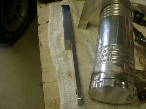 Polished metal automotive part on white cloth with tire detail