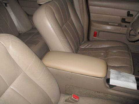 2004 Ford Crown Victoria - The interior of a 2004 Ford Crown Victoria shows tan leather seats and a center console.
