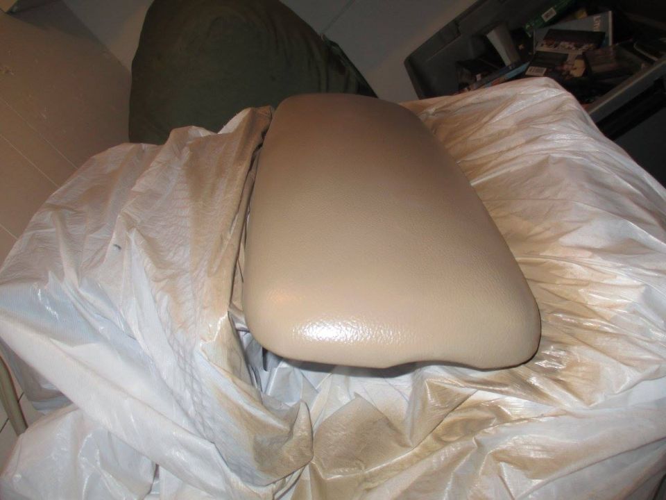 tan center console armrest covered in plastic sheeting