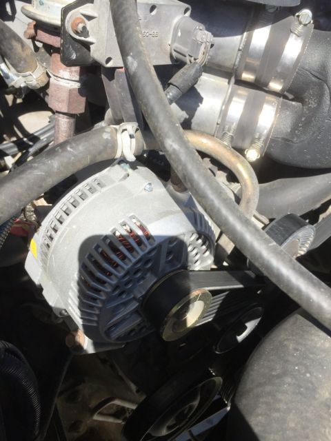 1996 Ford Bronco - Close-up view of the alternator and associated engine components, including hoses and belts.