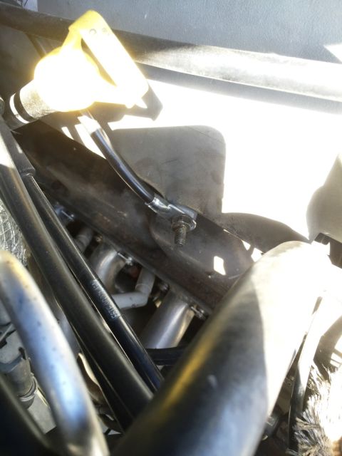 1996 Ford Bronco - Close-up view of engine components, including a yellow dipstick and various hoses and tubes.