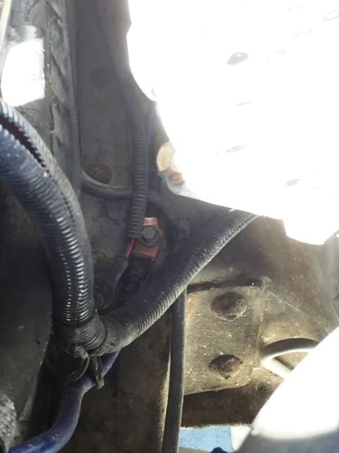 1996 Ford Bronco - Close-up view of wiring harness and a copper terminal in the engine bay.