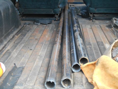1972 Ford Bronco - Several metal pipes are stored in the cargo area of a vehicle.
