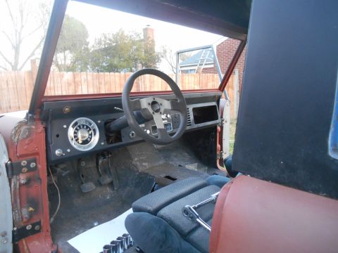 1972 Ford Bronco - The interior of a vehicle is shown with the dashboard and steering wheel exposed, indicating ongoing restoration work.