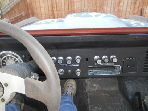 1972 Ford Bronco - The interior of a 1972 Ford Bronco shows its dashboard with a large steering wheel and various controls.