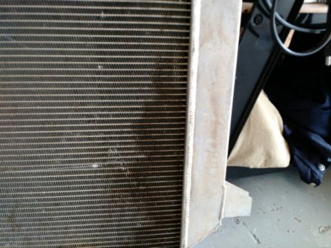 1992 Ford Bronco - A close-up view of a vehicle radiator, showing its intricate fin structure and metal frame.