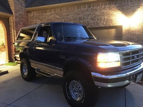 1996 Ford Bronco - This 1996 Ford Bronco is shown in a 3/4 front view, parked in a driveway at dusk.