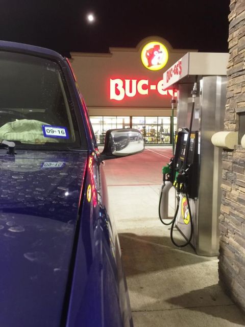 1996 Ford Bronco - A blue SUV is parked at a gas pump under the Buc-ee's sign at night.